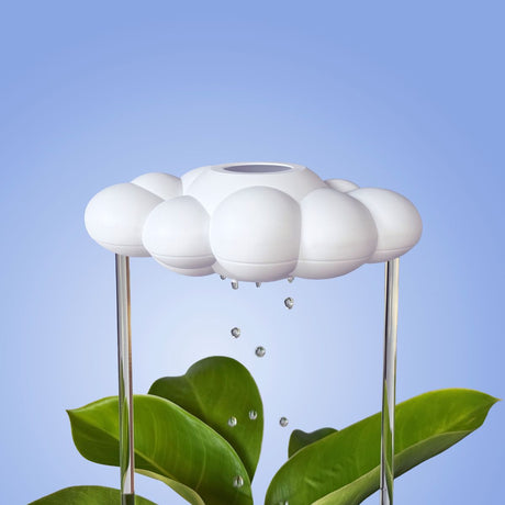 Cloud-shaped water dispenser with droplets falling onto green leaves against a blue background