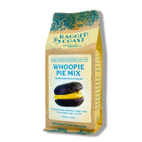 A bag of Ragged Coast Chocolate Baking Co. Whoopie Pie Mix, featuring a kraft paper bag with teal decorative patterns at the top and bottom, and a central label showing a chocolate and peanut butter whoopie pie.