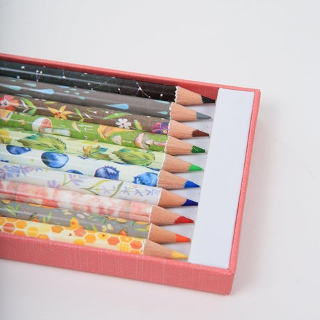 Set of colored pencils with floral designs in a pink box on a white background