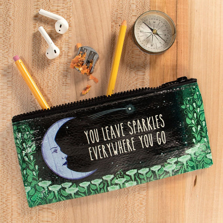Pencil case with motivational quote on a wooden surface with stationery items.