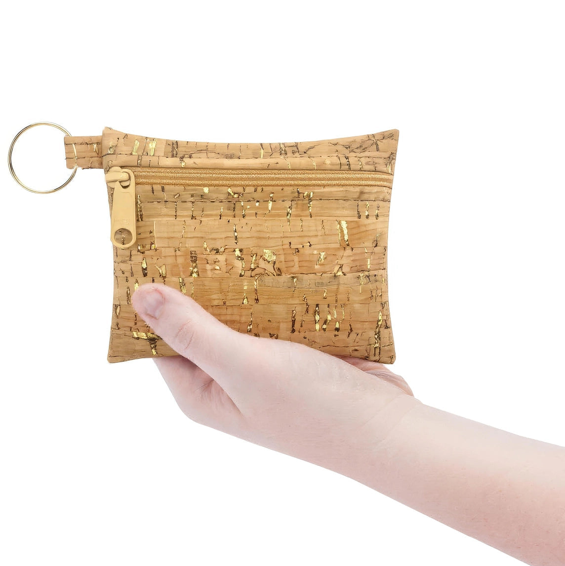 Hand holding a cork pouch with a key ring on a white background