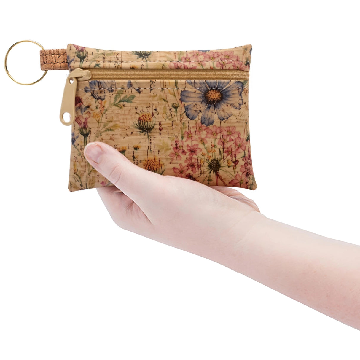 Floral-patterned cork keychain pouch held by a hand on a white background