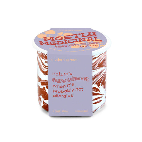 The mostly medicinal lemon balm altered herbs mug in its package - a burgundy and white marbled enamel mug with a light purple package that reads "nature's cure almost when its probably not allergies"
