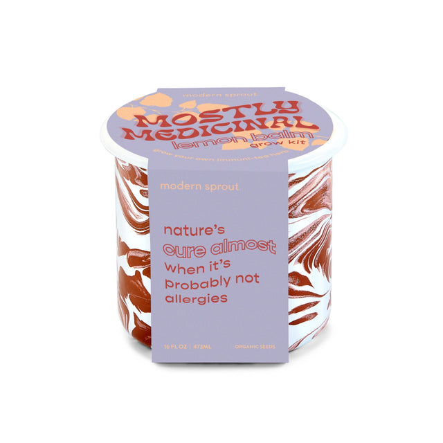 The mostly medicinal lemon balm altered herbs mug in its package - a burgundy and white marbled enamel mug with a light purple package that reads "nature's cure almost when its probably not allergies"