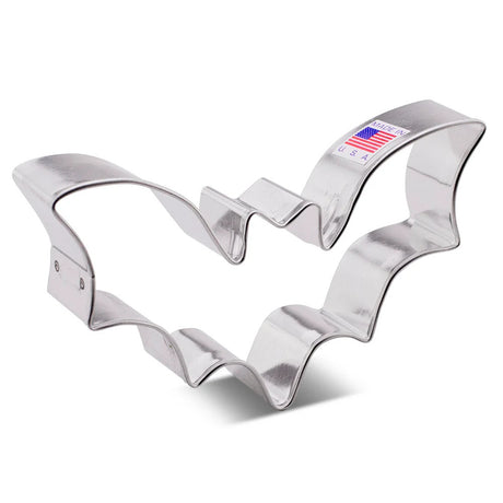 A tin cookie cutter in the shape of a flying bat with wings spread