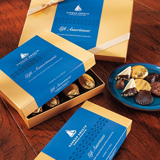 Harbor Sweets chocolate assortment in a blue and gold box on a wooden surface.