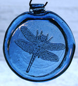 a blue, round glass suncatcher with a relief image of a dragonfly