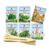 A collection of six herb seed packets from The Old Farmer's Almanac, including Dill, Cilantro, Italian Flat Leaf Parsley, Italian Large Leaf Basil, Chives, and Butterfly Milkweed, accompanied by wooden plant markers.