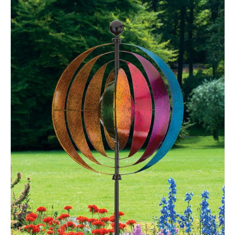 The Vertical Wind Spinner Illusion displayed in a garden, emphasizing its colorful design and vibrant effect as it catches the sunlight