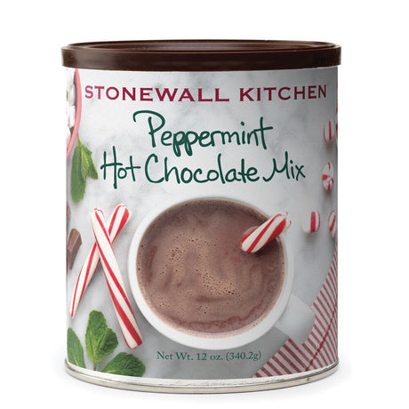 a can of peppermint hot chocolate mix with an image on the can of a marble countertop and overhead view of a white mug of hot chocolate with red and white striped candy canes around it