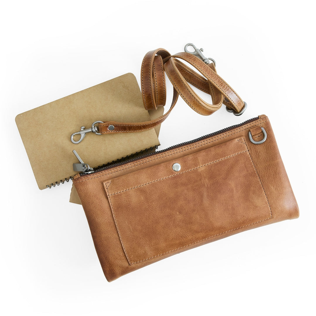Brown leather clutch with a matching cardholder on a white background