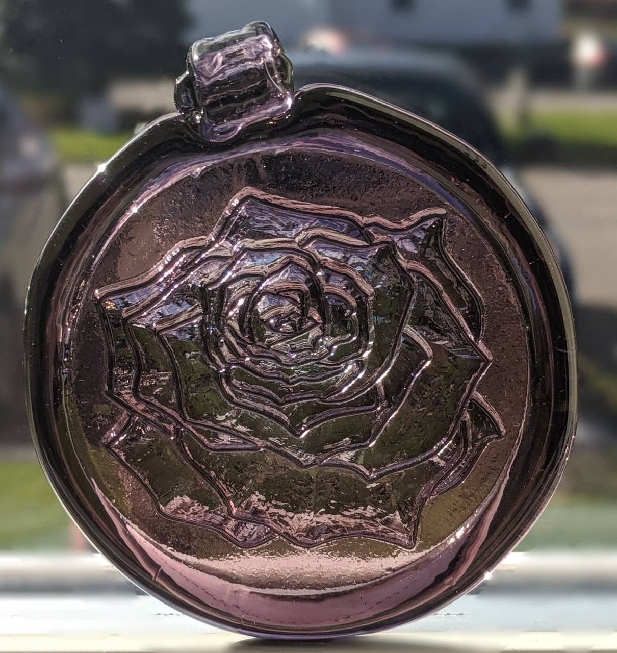 Glass suncatcher with a rose design shown in lighter purple.