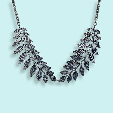 Silver leaf necklace on a light blue background
