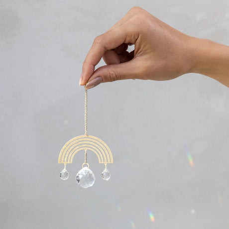a hand dangling the mini rainbow suncatcher to give an idea of scale