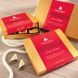 Harbor Sweets Sweet Sloops chocolate boxes on a wooden surface with a rope.