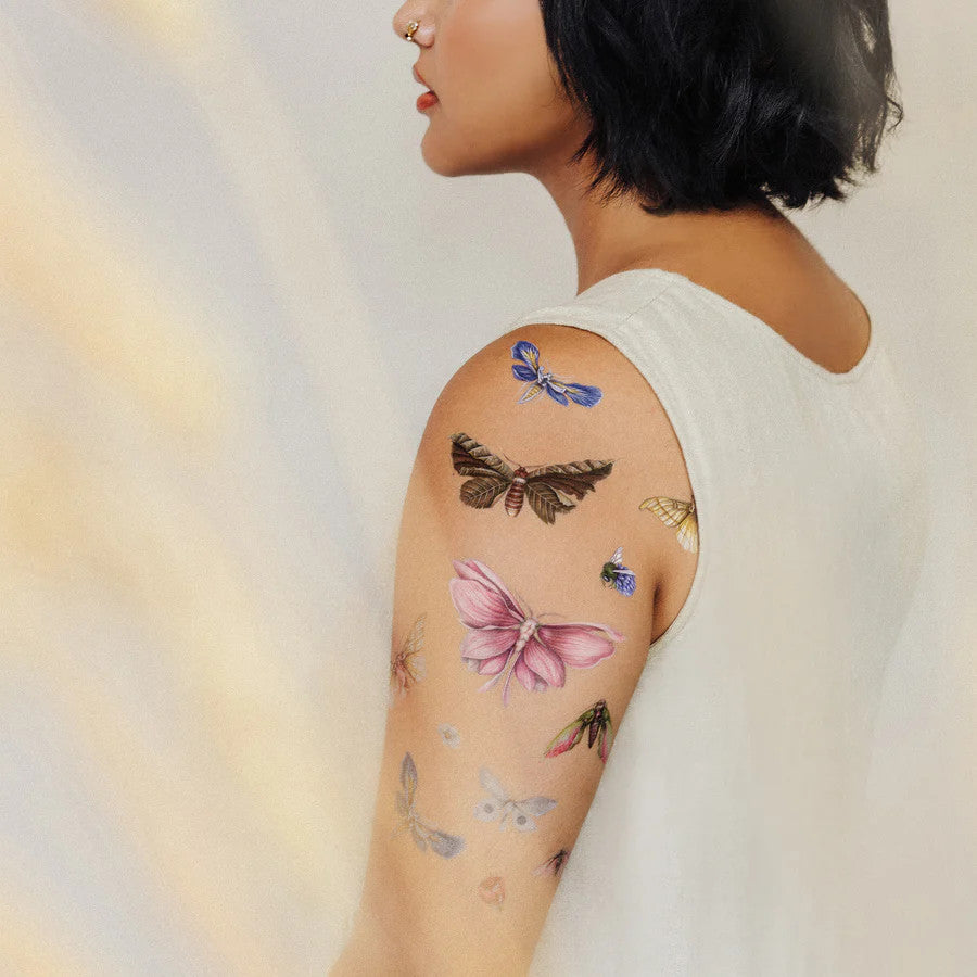 a rear side angle of a model's arm with the floraflies tattoos applied all over her upper arm